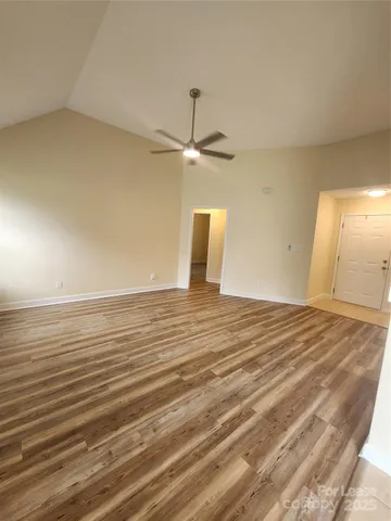 a view of a room with wooden floor and a ceiling fan