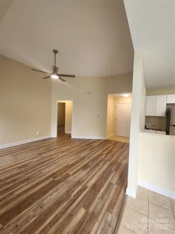 a view of a room with a ceiling fan and wooden floor