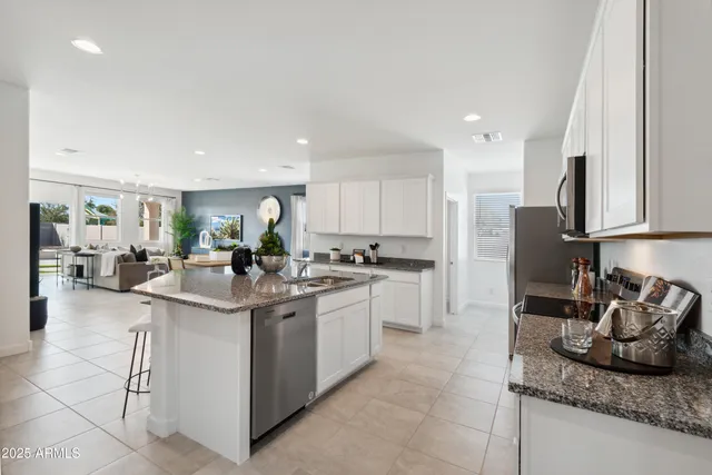 a kitchen with stainless steel appliances kitchen island granite countertop a sink and cabinets