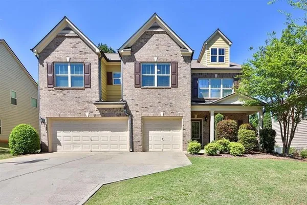 a front view of a house with a yard and garage