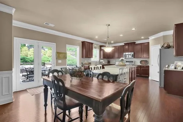 a view of a dining room and livingroom with furniture wooden floor a chandelier