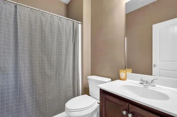 a bathroom with a sink a toilet and shower curtain