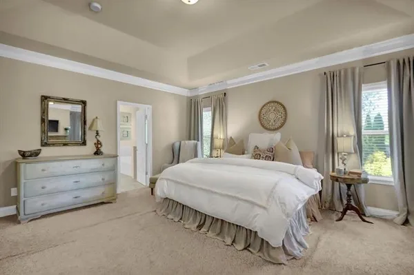 a bedroom with a bed and large windows