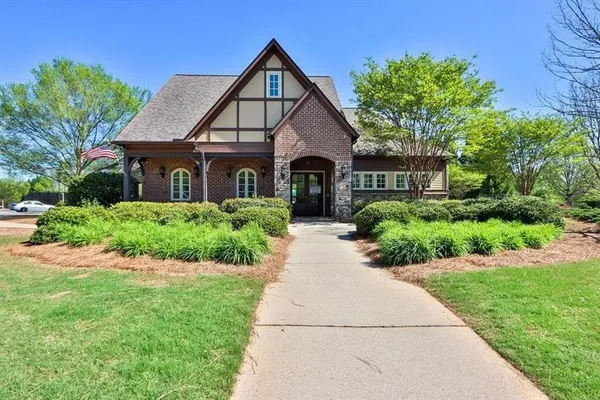 a front view of a house with a yard and potted plants