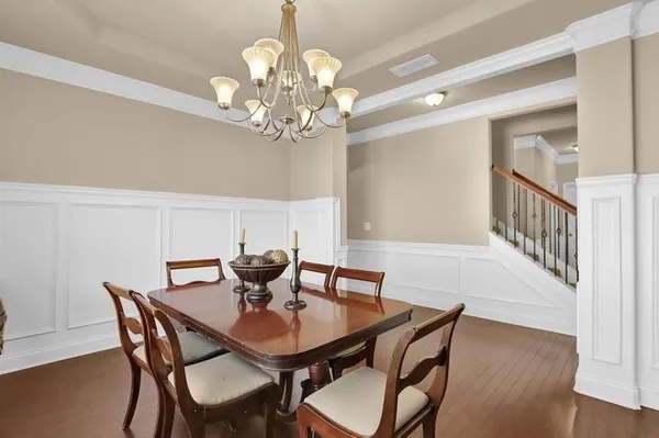 a view of a dining room with furniture a chandelier and wooden floor
