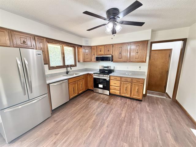 8567 Valley View Drive Stillman Valley, IL 61084 - Photo 11 of 29 a kitchen with stainless steel appliances a refrigerator a sink dishwasher a stove and white countertops with wooden floor