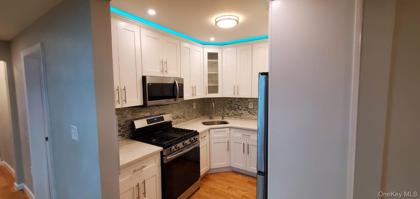 914 Duncan Street Bronx, NY 10469 - Photo 9 of 10 a kitchen with a stove and a microwave