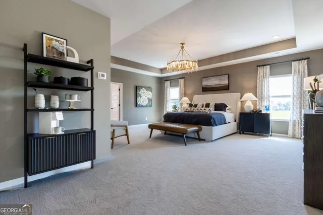 a spacious bedroom with a bed and a chandelier