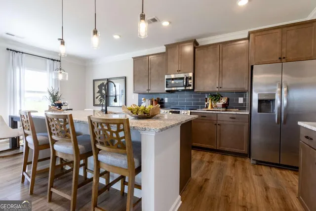 a kitchen with kitchen island granite countertop a center island stainless steel appliances cabinets and a counter top space
