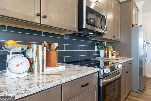 a kitchen with granite countertop a sink a stove and cabinets