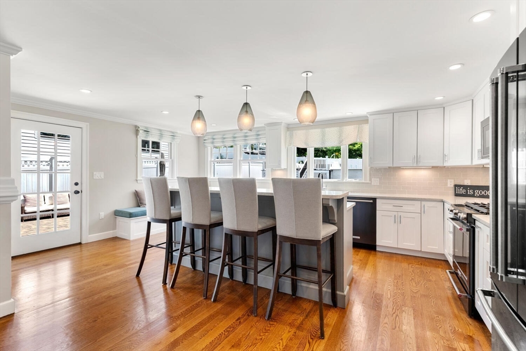 149 Robbins Road Watertown, MA 02472 - Photo 11 of 33 a kitchen with stainless steel appliances a dining table chairs stove refrigerator and cabinets
