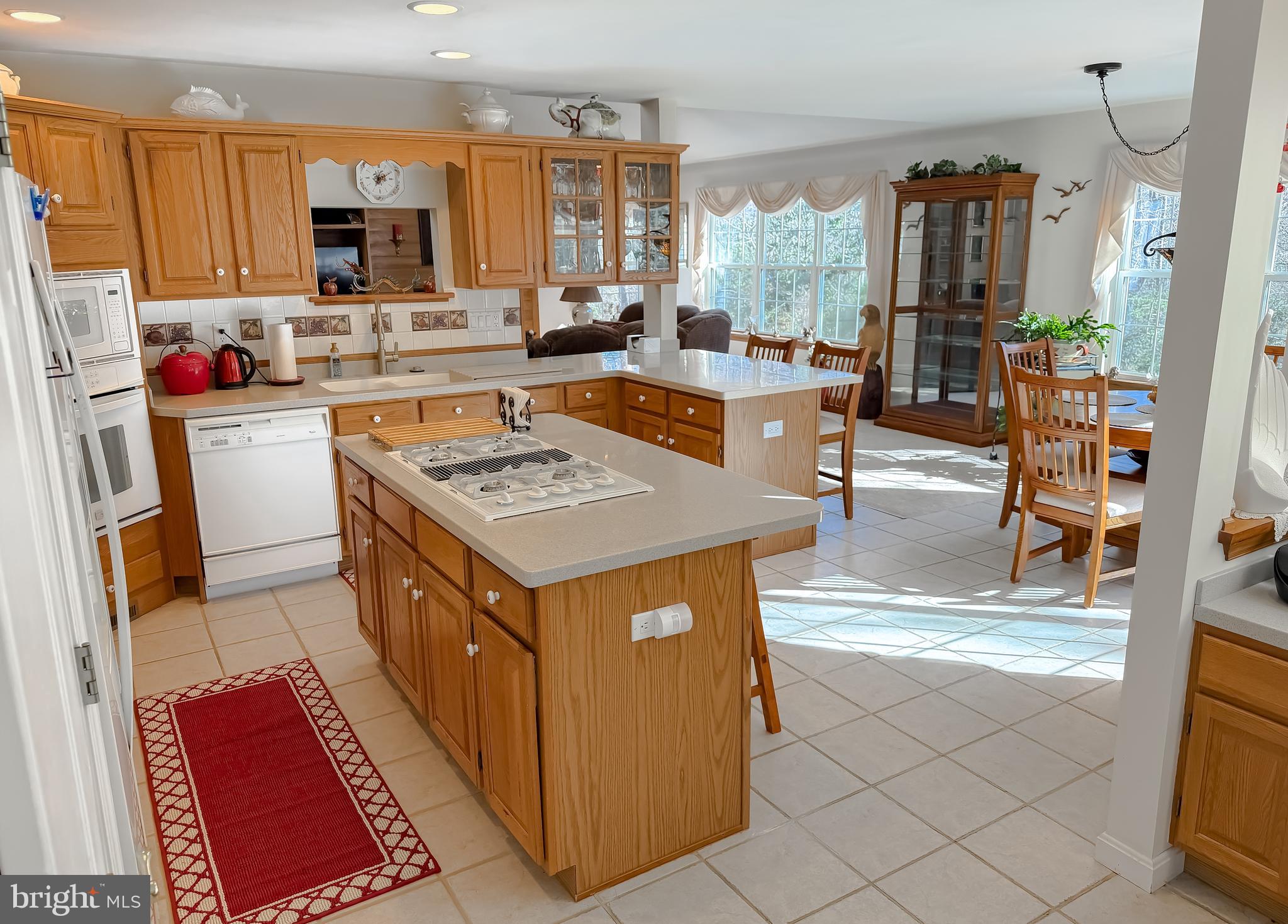 48712 Packer Court St. Inigoes, MD 20684 - Photo 13 of 55 a kitchen with stainless steel appliances granite countertop a stove top oven a sink a dining table and chairs with wooden floor