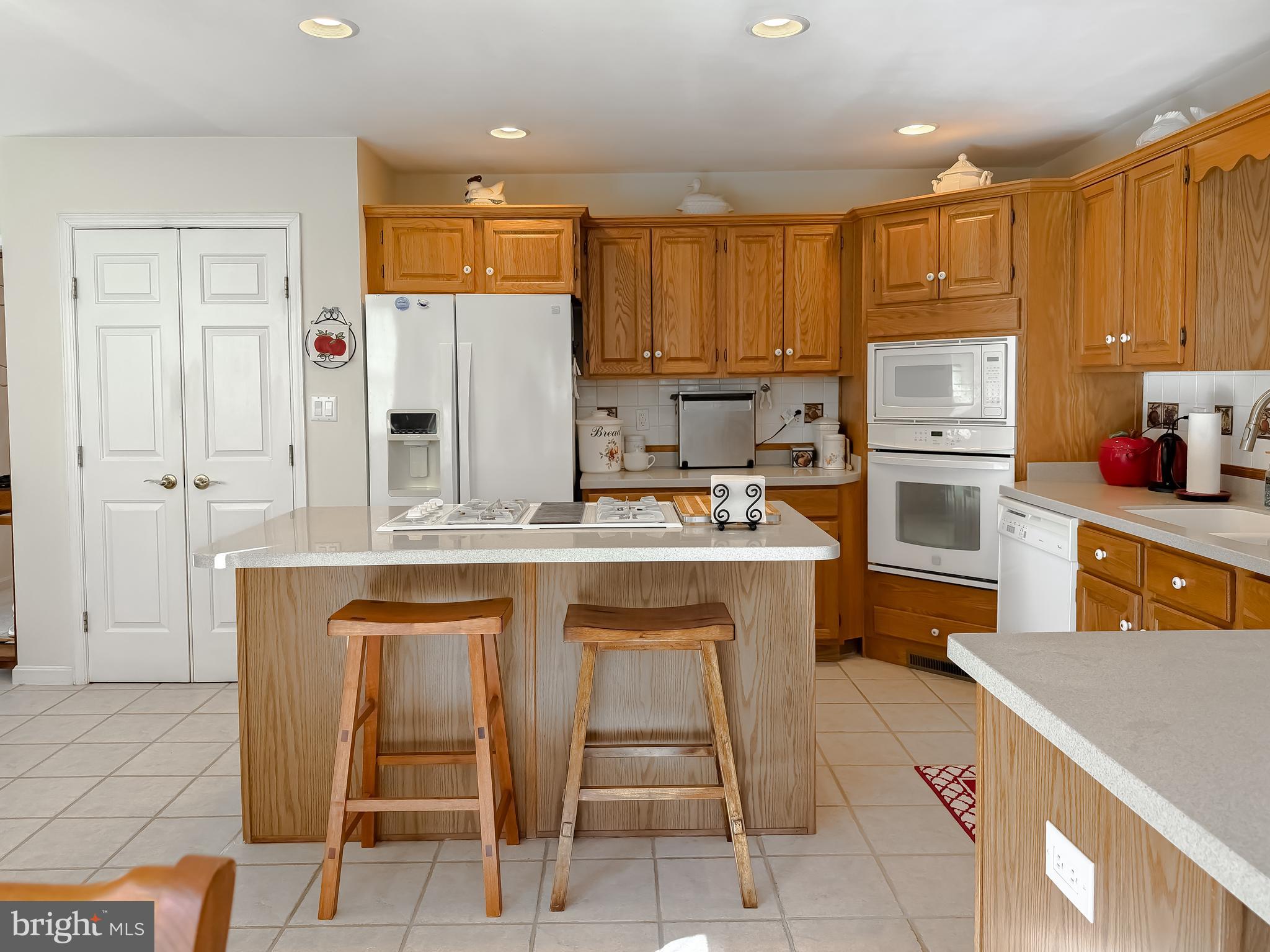 48712 Packer Court St. Inigoes, MD 20684 - Photo 15 of 55 a kitchen with kitchen island granite countertop wooden cabinets and refrigerator