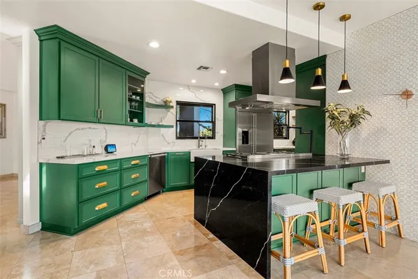 a kitchen with stainless steel appliances granite countertop a refrigerator a sink and a stove