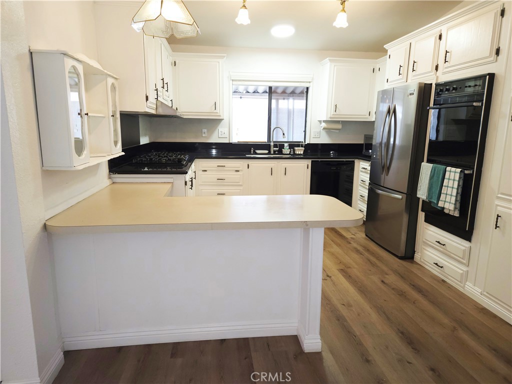 840 East Foothill Boulevard, Unit 203 Azusa, CA 91702 - Photo 14 of 21 a kitchen with stainless steel appliances a refrigerator a stove a sink and white cabinets