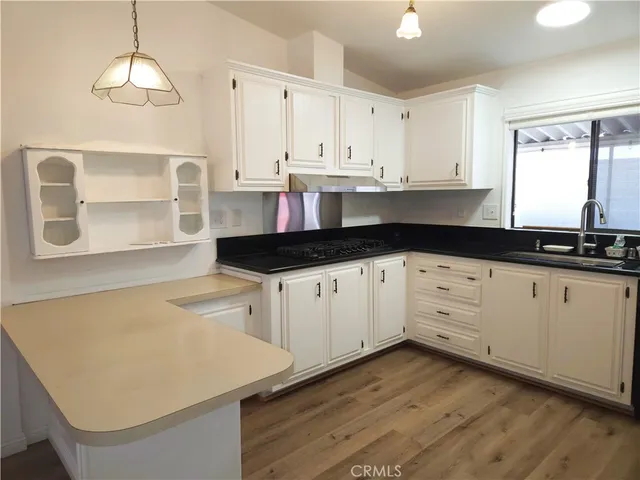 a kitchen with granite countertop white cabinets and white appliances