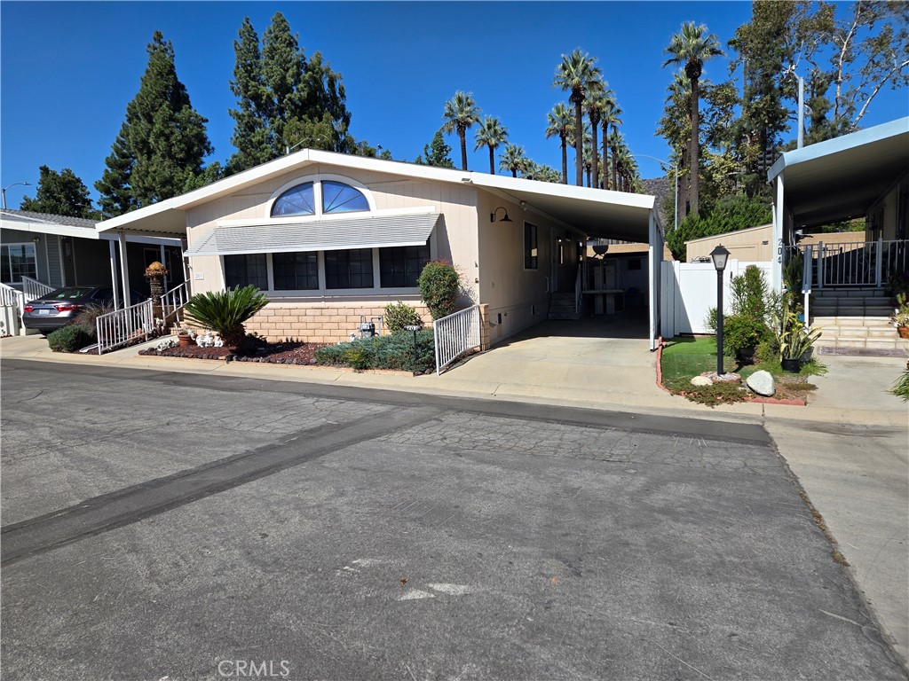 840 East Foothill Boulevard, Unit 203 Azusa, CA 91702 - Photo 5 of 21 a front view of a house with a yard and garage