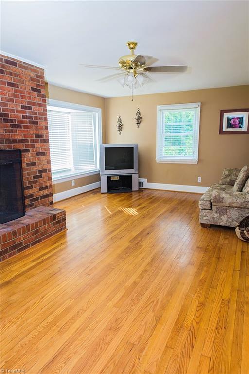 7014 Ridge Road Lexington, NC 27295 - Photo 13 of 21 Inviting, large living room with wood flooring and wood burning fireplace. Ceiling fans throughout home.