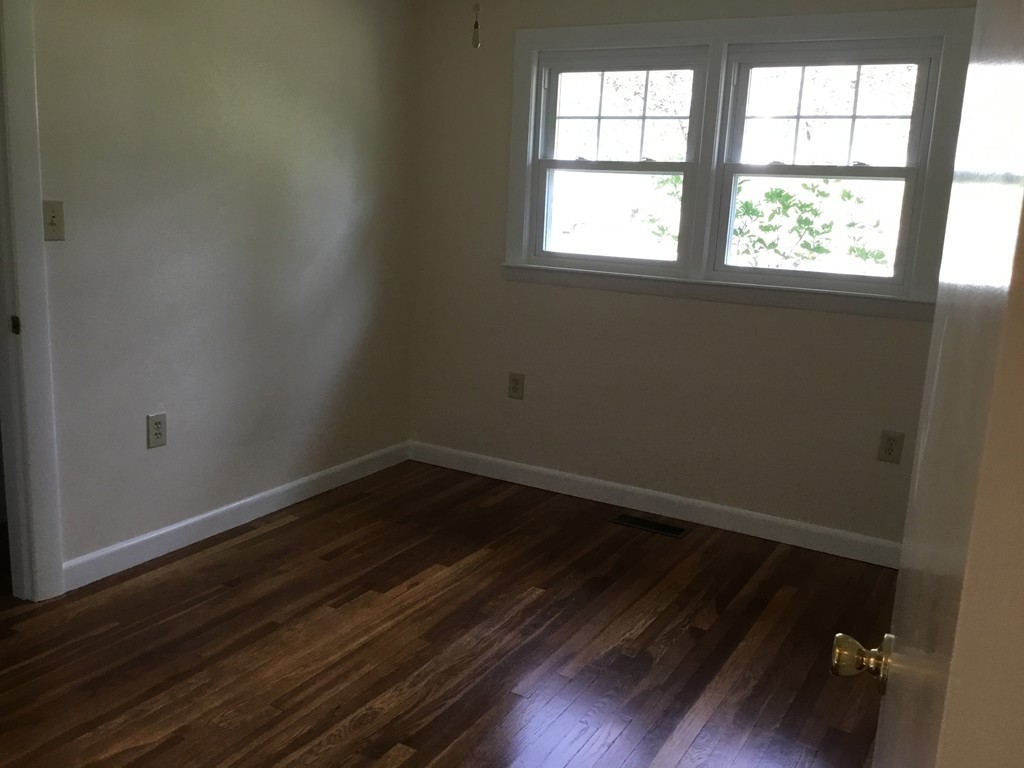 29 Boston Road Sutton, MA 01590 - Photo 10 of 16 an empty room with wooden floor and windows in it