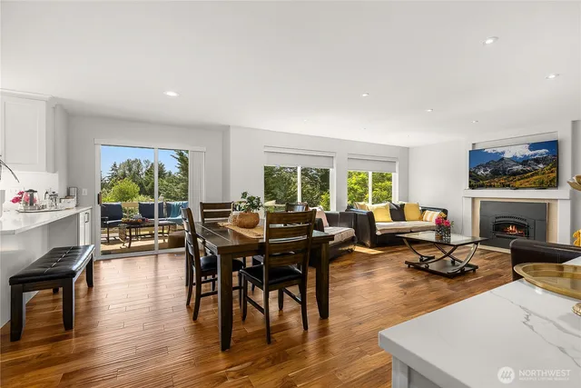 a living room with furniture a fireplace and a large window