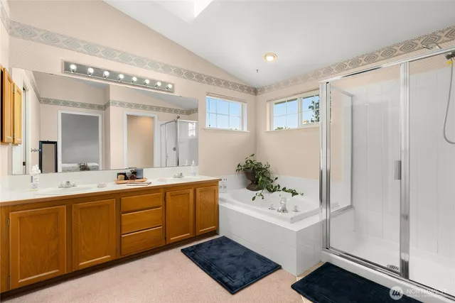 a spacious bathroom with a double vanity sink mirror and shower
