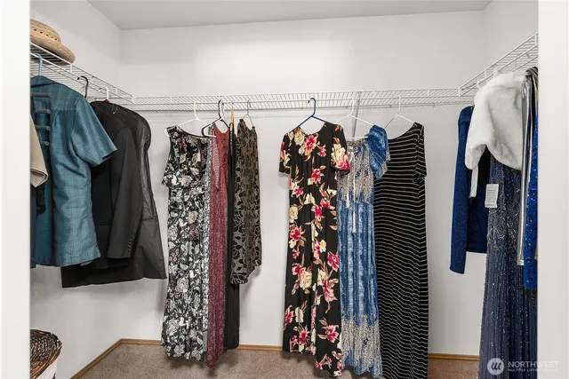 a view of walk in closet with clothes