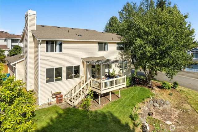 a white house with a large garden and wooden fence