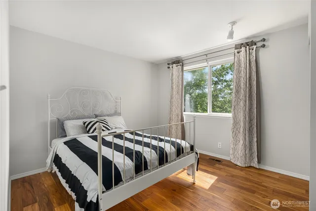 a bedroom with a bed and wooden floor