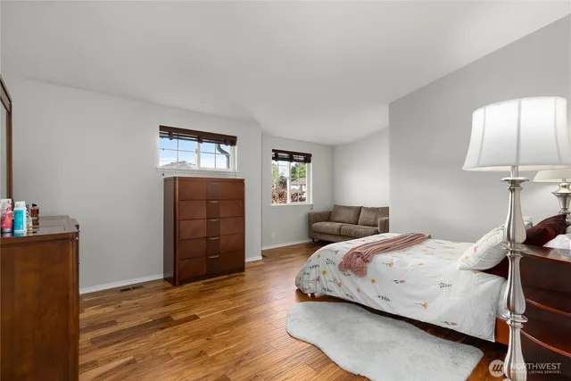a bedroom with a bed and wooden floor