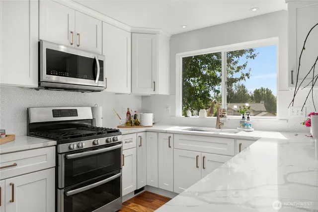 a kitchen with stainless steel appliances a stove a sink and a microwave