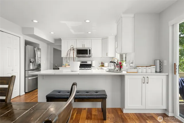 a kitchen with white cabinets and appliances