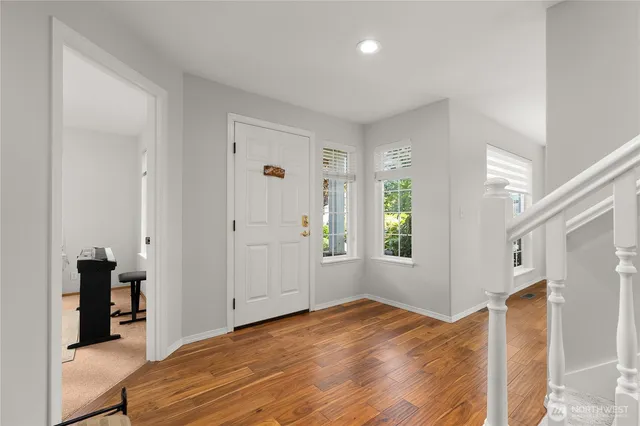a view of a bedroom with wooden floor and windows