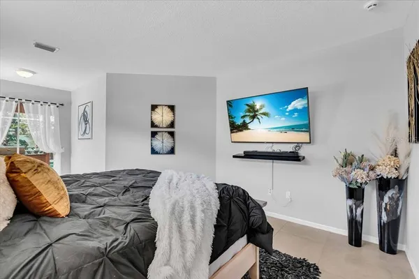 a bedroom with a bed and a flat screen tv