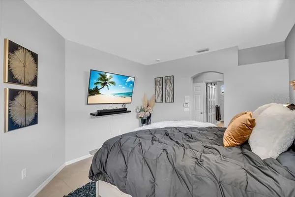 a bed sitting in a bedroom and view of living room