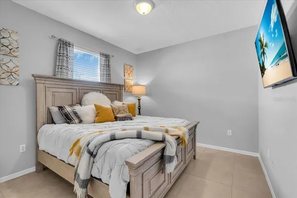a bed sitting in a bedroom next to a window
