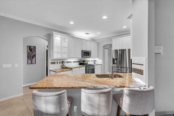a kitchen with stainless steel appliances granite countertop a sink and refrigerator
