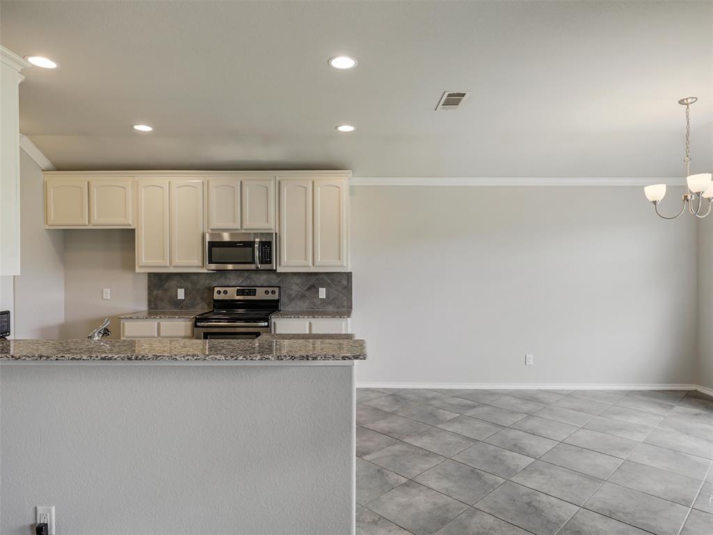 132 County Road 4213 Decatur, TX 76234 - Photo 6 of 27 a kitchen with stainless steel appliances granite countertop a stove a sink and a refrigerator