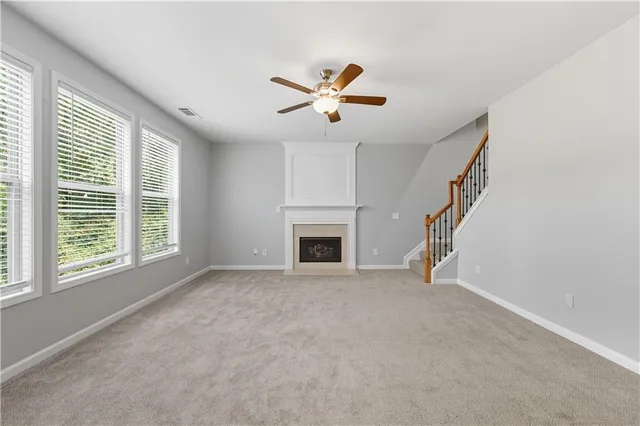 a view of an empty room with a fireplace and a window