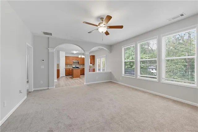 an empty room with windows and fireplace