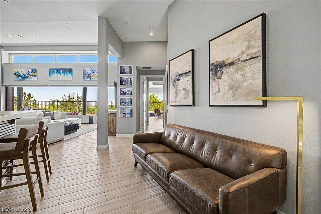 6014 Willow Ridge Court Las Vegas, NV 89135 - Photo 12 of 99 This bright interior features large windows overlooking an inviting outdoor area with a railing and mature trees.