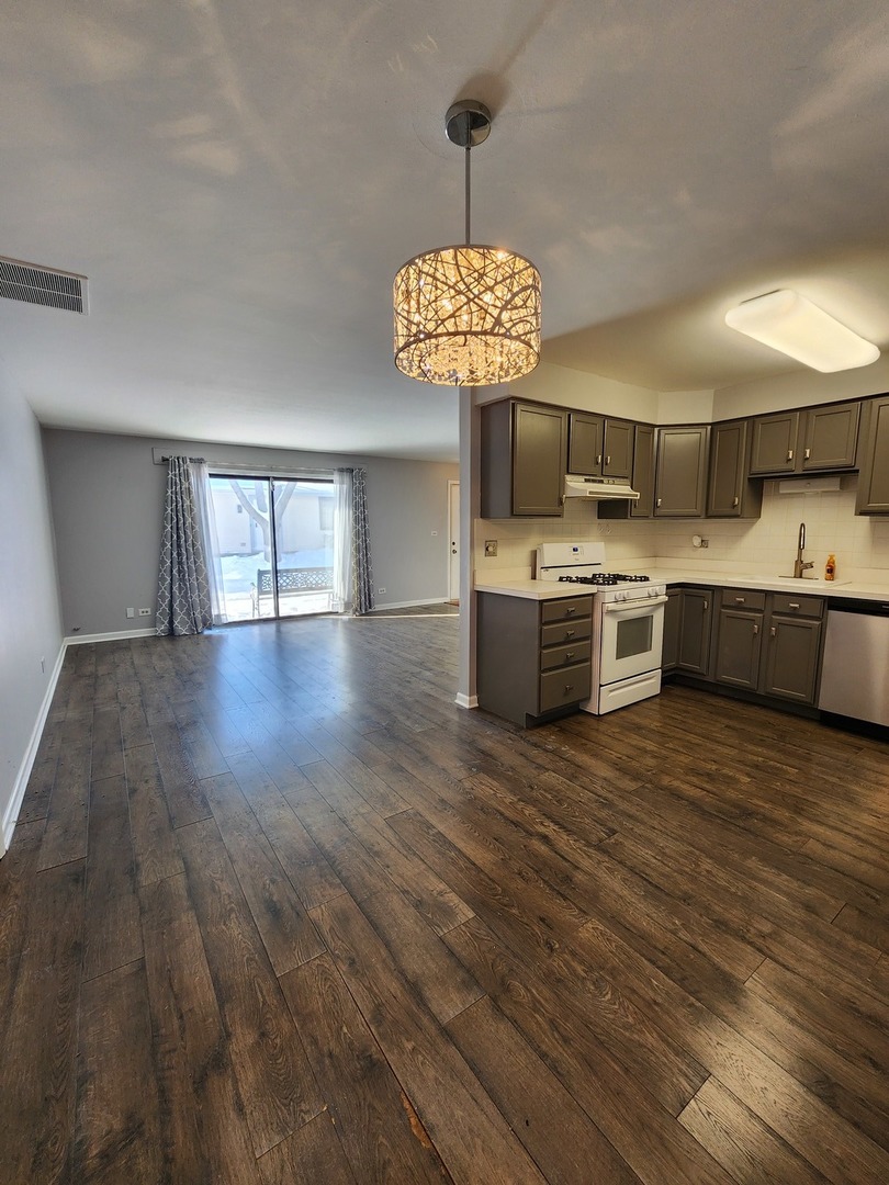 123 Brewster Court, Unit B Bloomingdale, IL 60108 - Photo 12 of 23 a view of a room with wooden floor and chandelier