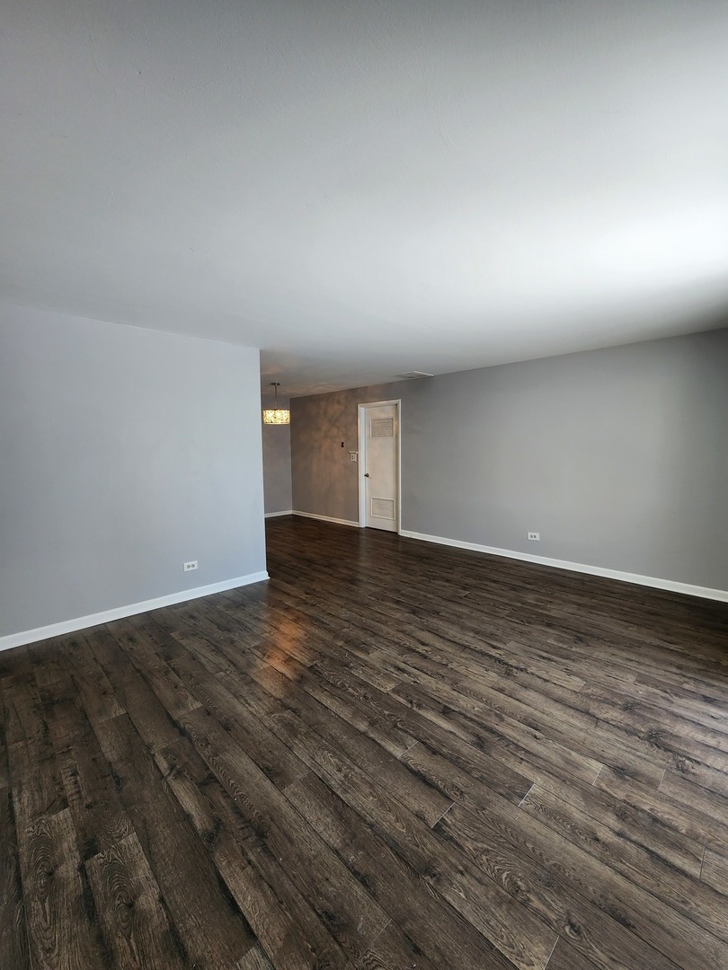 123 Brewster Court, Unit B Bloomingdale, IL 60108 - Photo 15 of 23 an empty room with wooden floor and windows
