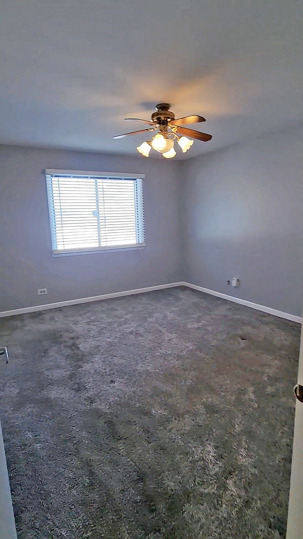 123 Brewster Court, Unit B Bloomingdale, IL 60108 - Photo 19 of 23 an empty room with windows and fan