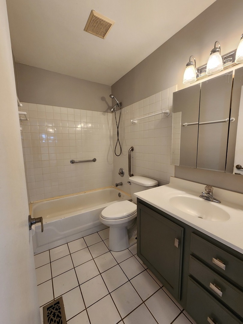 123 Brewster Court, Unit B Bloomingdale, IL 60108 - Photo 20 of 23 a bathroom with a sink a toilet and shower