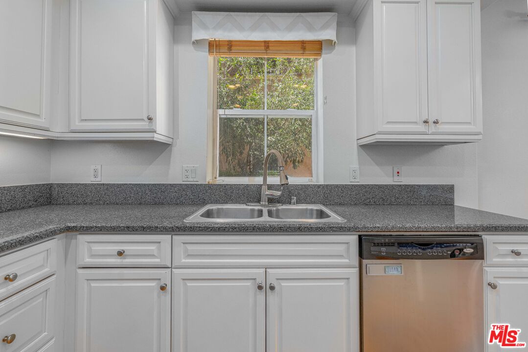 13080 Pacific Promenade, Unit 109 Playa Vista, CA 90094 - Photo 11 of 60 a kitchen with granite countertop white cabinets and a window