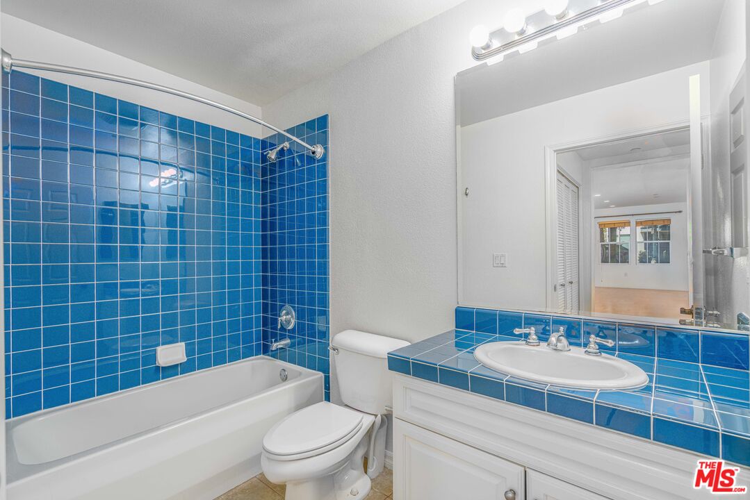 13080 Pacific Promenade, Unit 109 Playa Vista, CA 90094 - Photo 16 of 60 a bathroom with a sink a toilet a mirror and shower