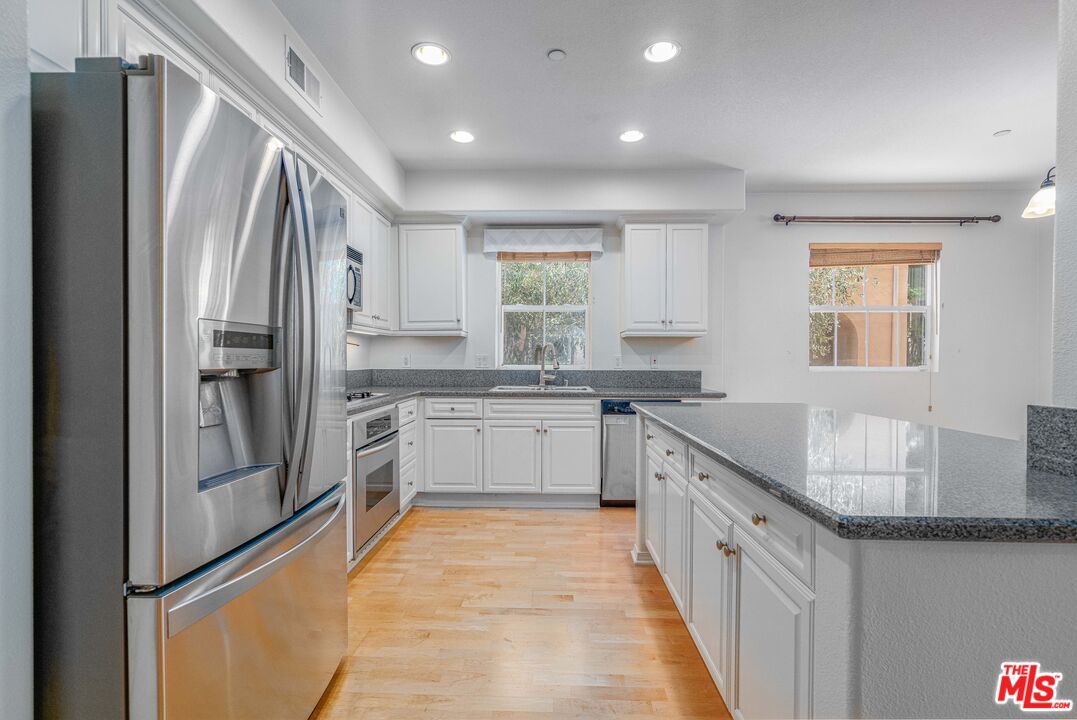 13080 Pacific Promenade, Unit 109 Playa Vista, CA 90094 - Photo 4 of 60 a large kitchen with stainless steel appliances granite countertop a refrigerator and a sink