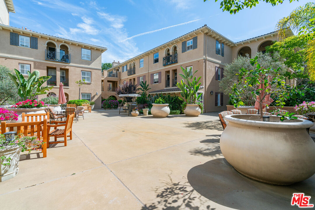 13080 Pacific Promenade, Unit 109 Playa Vista, CA 90094 - Photo 44 of 60 a view of a patio with dining table and chairs under an umbrella