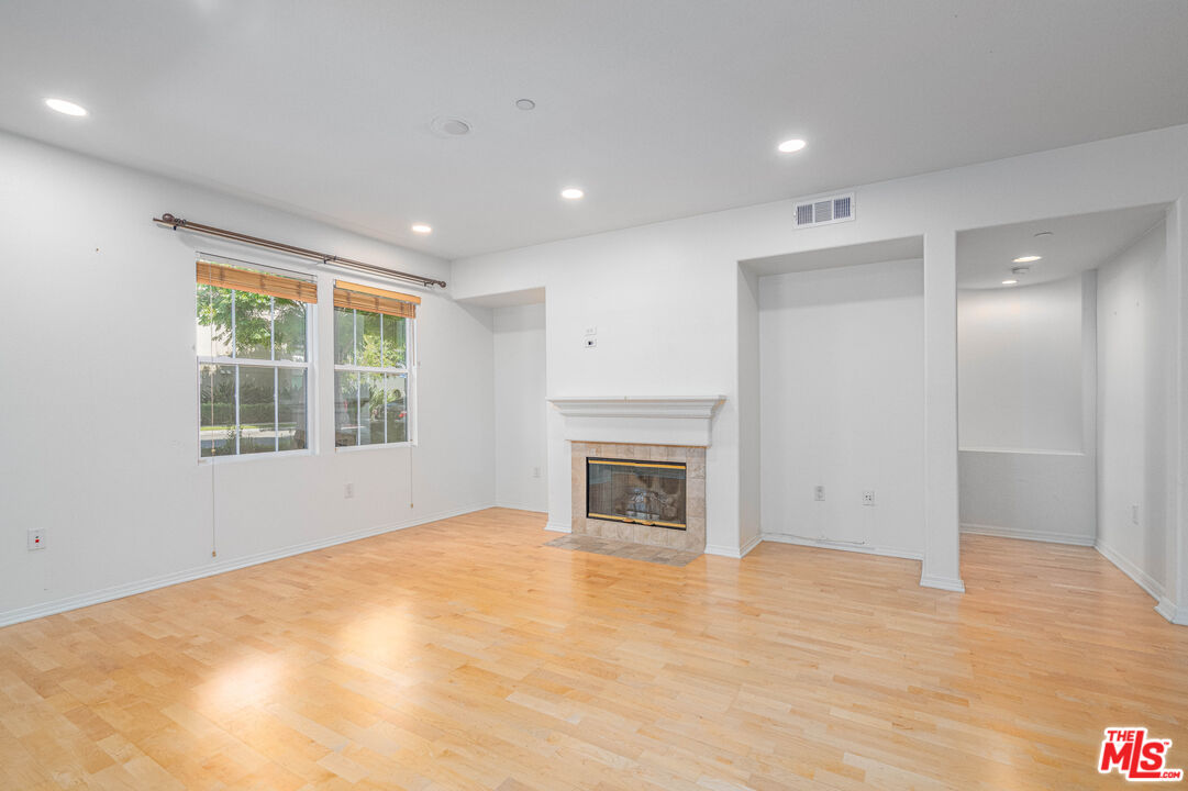 13080 Pacific Promenade, Unit 109 Playa Vista, CA 90094 - Photo 7 of 60 a view of empty room with a fireplace and wooden floor
