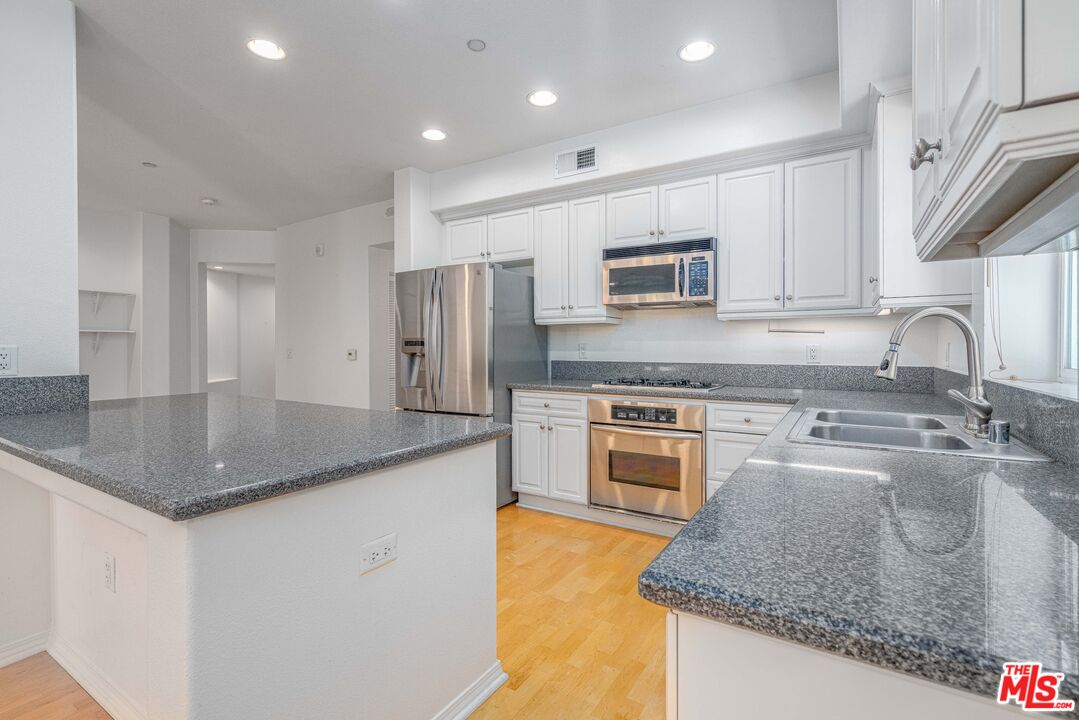 13080 Pacific Promenade, Unit 109 Playa Vista, CA 90094 - Photo 9 of 60 a kitchen with stainless steel appliances granite countertop a sink stove and refrigerator